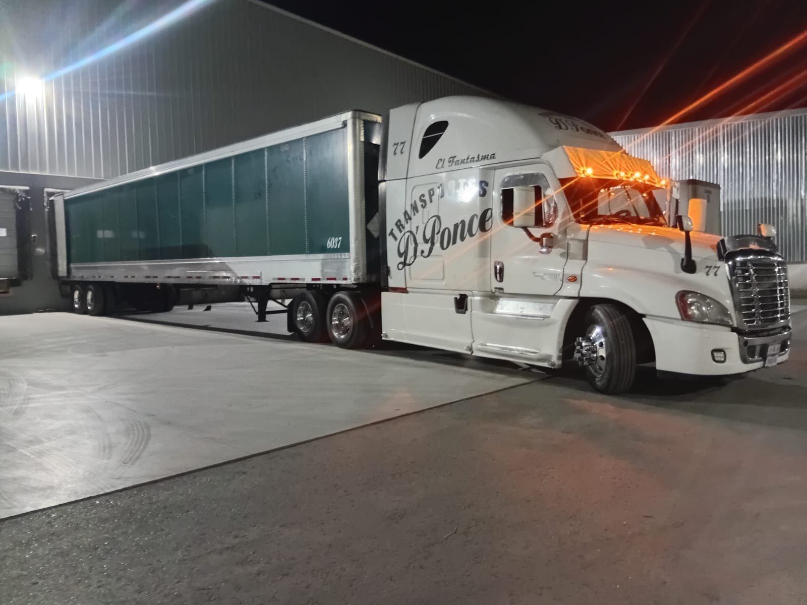 Unidad 77 de Transportes D Ponce enganchada a su caja en el andén, de noche