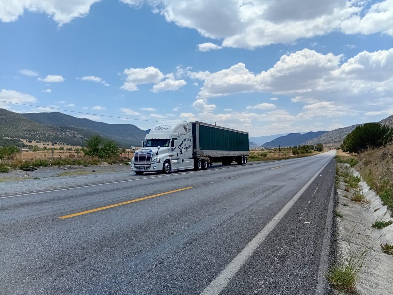 Tractocamión de Transportes D Ponce con caja en carretera federal, entre montañas